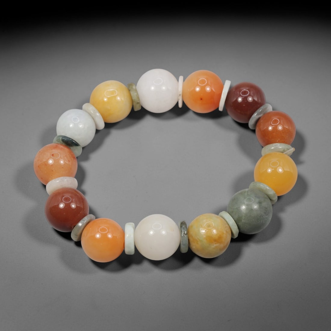 A Chinese Quartz and Jadeite Jade Bead Bracelet, 20th Century, 45ZK: Strung with spherical beads of quartz and jadeite jade, interspersed with flat disc-shaped spacers. The quartz beads display natural color variation, including white, yellow, orange, and reddish-brown