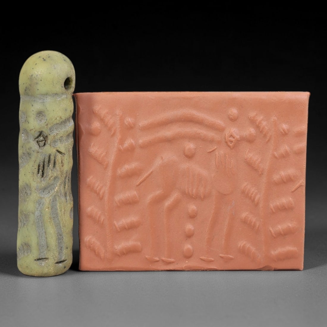 Ancient Serpentine Cylinder Seal - Mesopotamian Ibex & Tree, 79FX: Carved from serpentine, this cylinder seal follows the classic cylindrical form of ancient Mesopotamian administrative and ritual artifacts. Its surface bears a detailed figural scene, featuring two i
