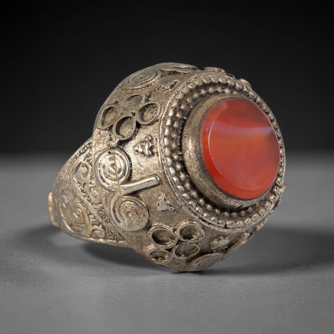 Antique Qajar Dynasty Silvered Carnelian Dome Ring - US Size 8, 67BA: This antique ring, crafted during the Qajar Dynasty of Persia, features a striking domed bezel centered with a polished oval carnelian cabochon, surrounded by intricate beaded granulation and decorati