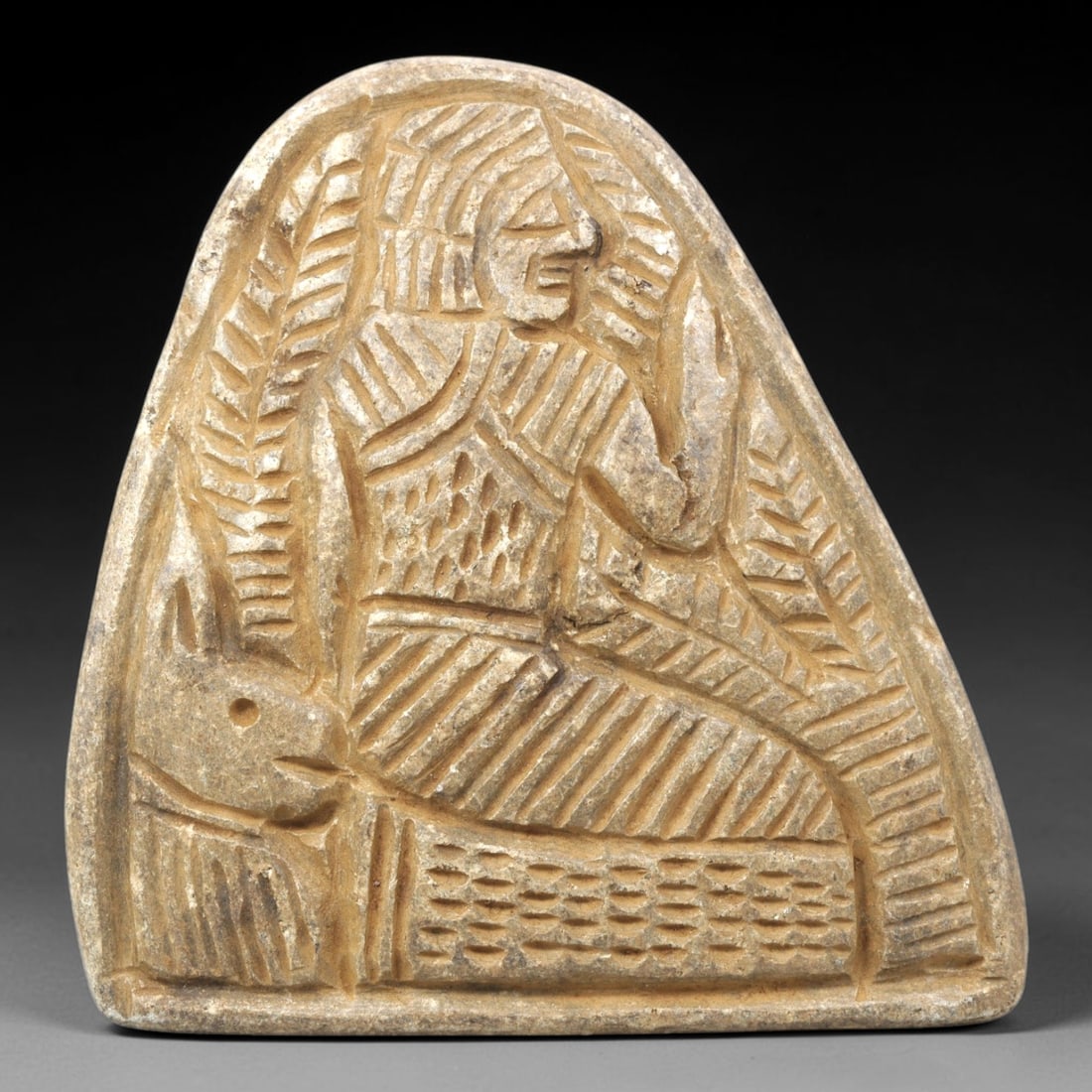 Ancient Stone Plaque Relief - Near Eastern Human & Feline Figural Plaque, 6ZY: Carved from a single piece of stone, this triangular relief plaque depicts a stylized seated human figure in profile beside a feline, rendered in the linear, incised artistic tradition of the ancient