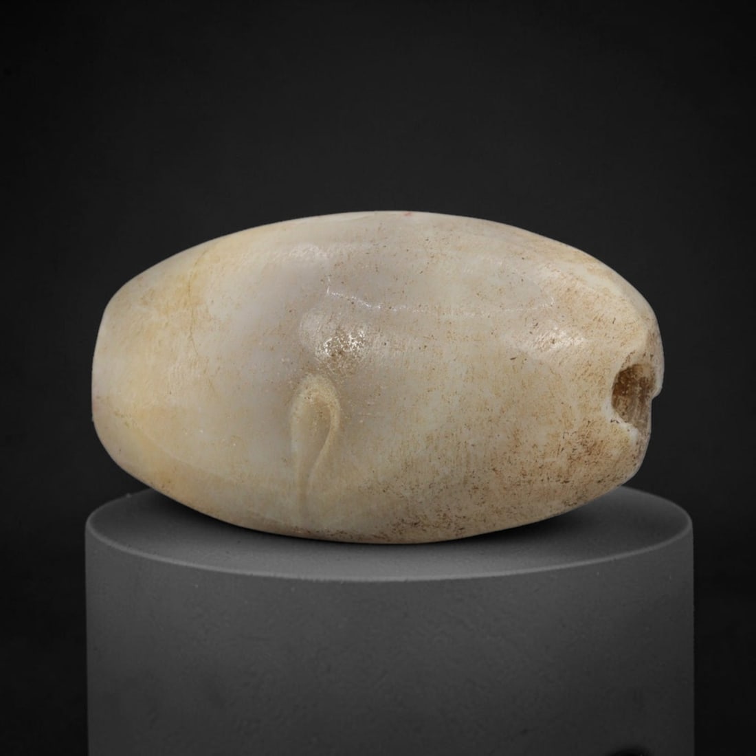 Ancient Agate Bead - Western Asiatic Oval Bead, 6XW: This bead is fashioned from creamy-white banded agate, shaped into a smooth, elongated oval form with a centrally drilled axial suspension hole, characteristic of Western Asiatic lapidary traditions d