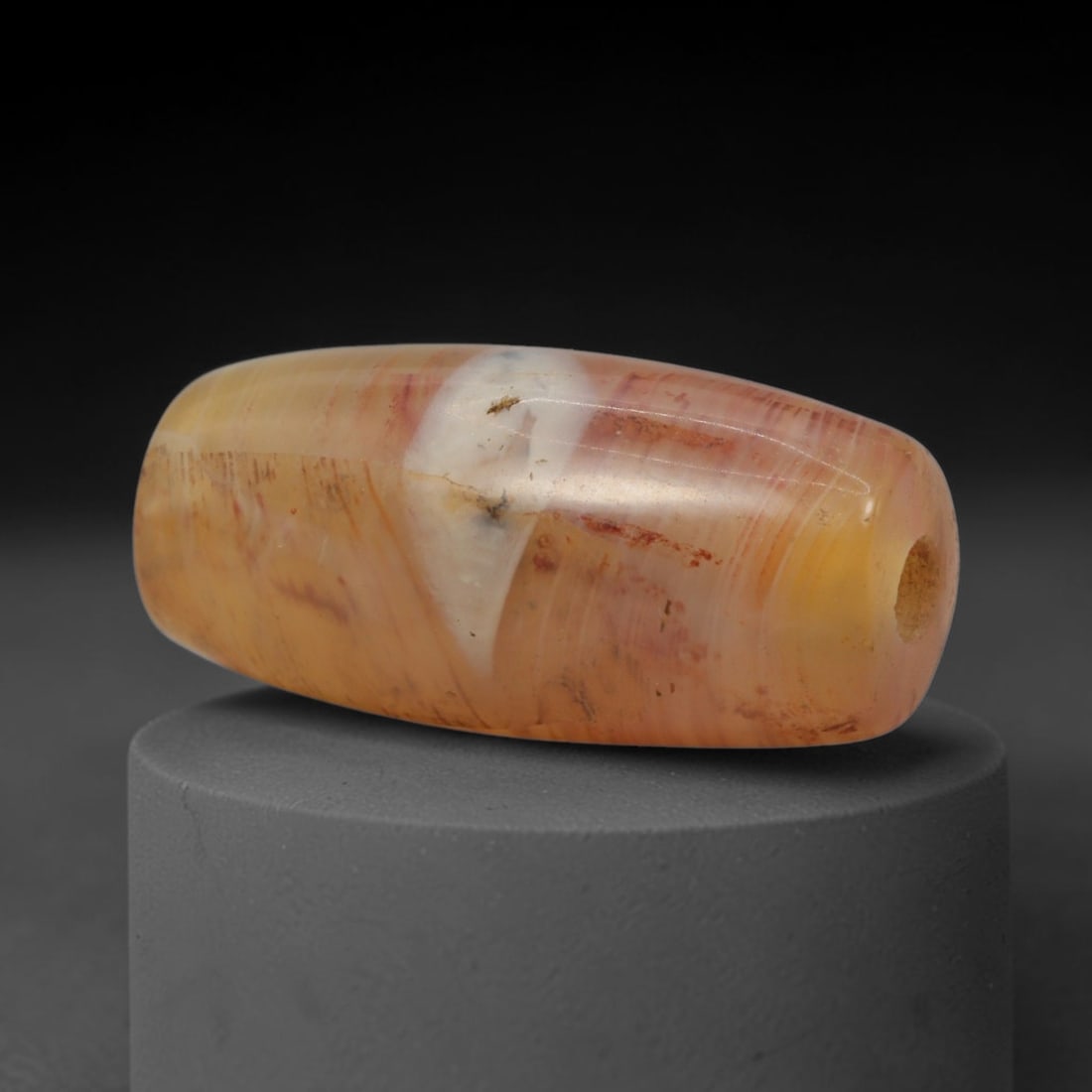 Ancient Agate Bead - Indus Valley Banded Barrel Bead, 2XW: This bead is fashioned from translucent honey-amber and creamy-white banded agate, shaped into a smooth, elongated barrel form with a precisely centered axial drill hole, characteristic of Indus Valle
