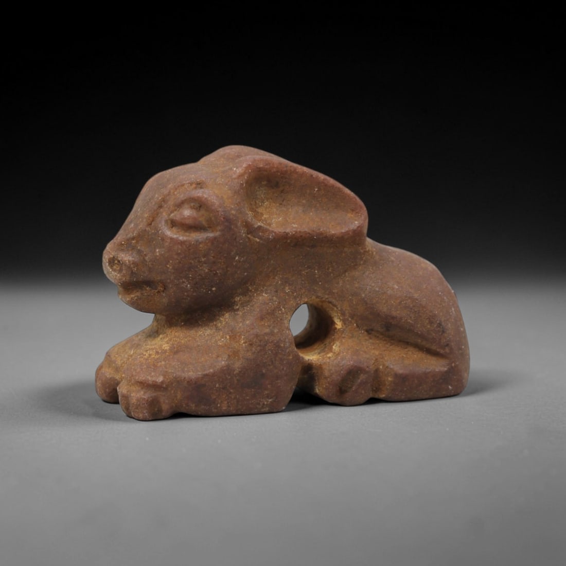 Ancient Stone Hare Amulet - Near Eastern Figurine, 100XV: This amulet is carved from a warm reddish-brown stone with subtle earthy tonal shifts and a natural matte patina across its surface, crafted using a simplified yet expressive carving technique that ca