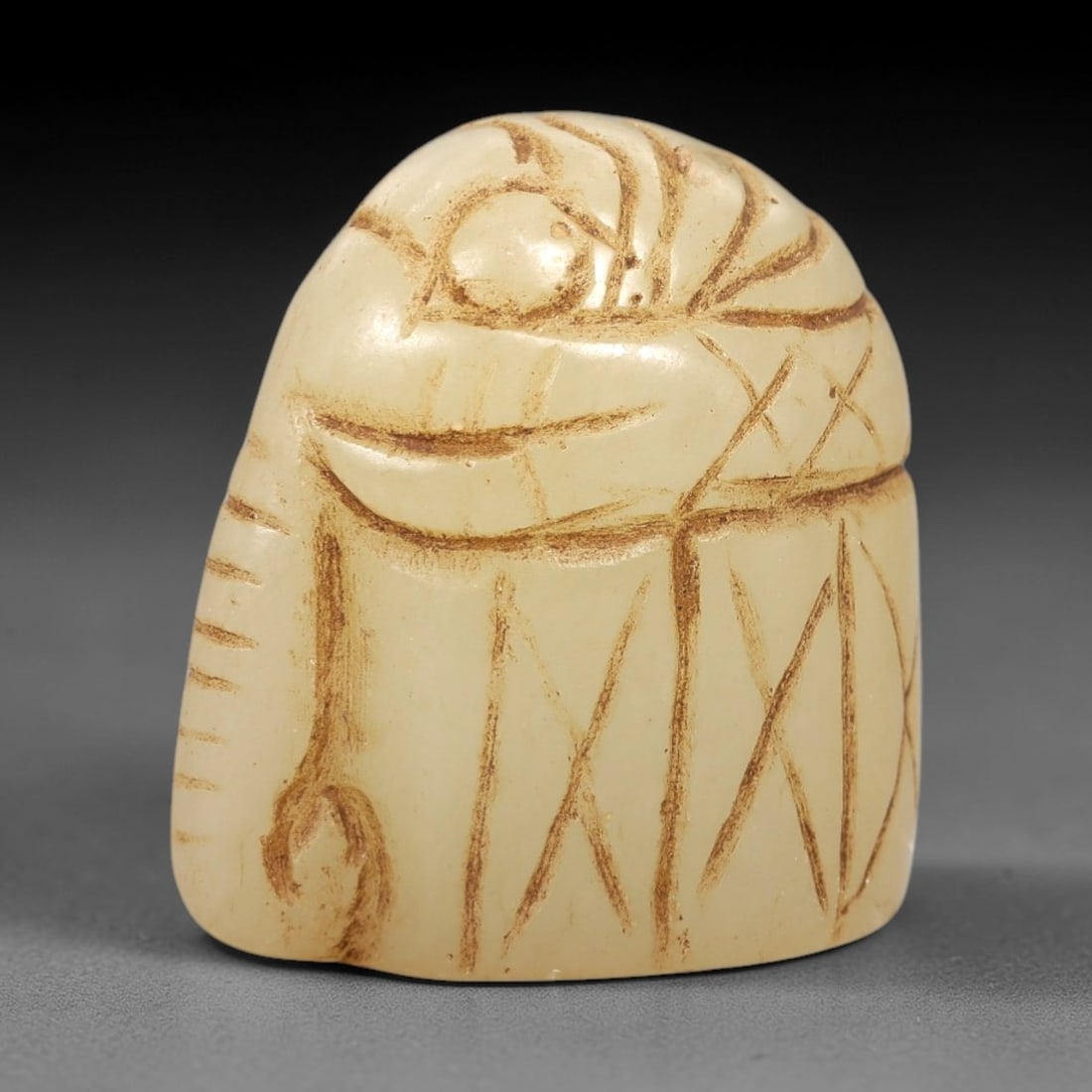 Ancient Serpentine Elephant - Near Eastern Figurine, 67AL: This artifact is carved from serpentine, depicting a stylized elephant form with a compact, rounded body and incised decorative motifs including linear and cross-hatch patterns on the surface. The car