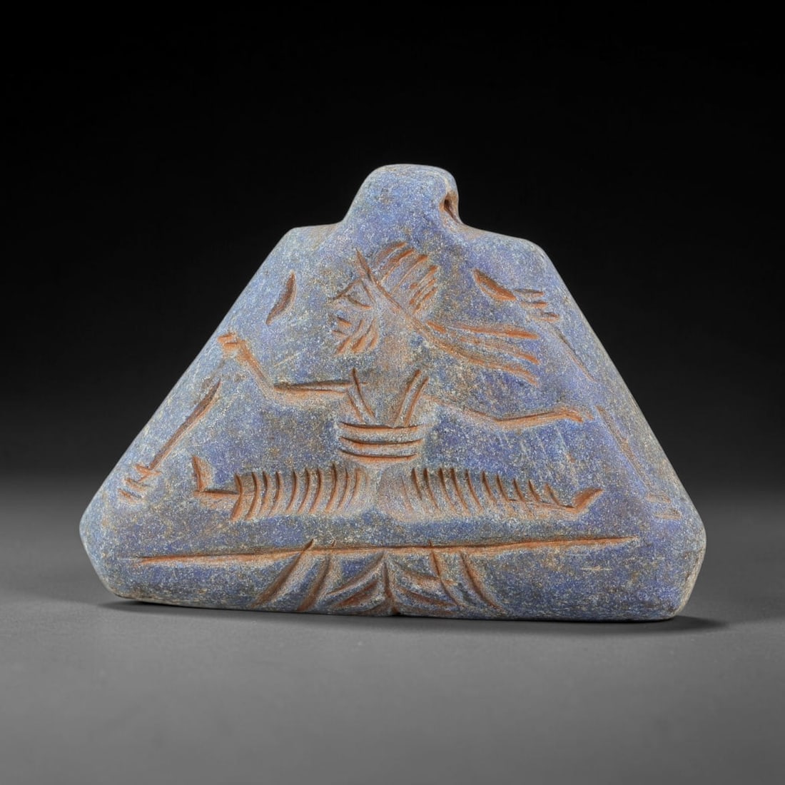 Ancient Lapis Lazuli Amulet - Near Eastern Anthropomorphic Figurine, 4BA: Carved from lapis lazuli, the amulet is shaped as a stylized anthropomorphic figure, with a suspension hole drilled through the top for wear as a protective talisman. The figure is detailed with incis