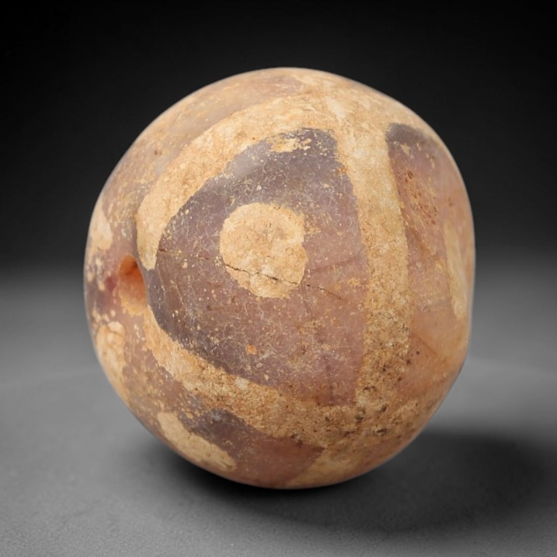 Ancient Carnelian Etched Bead - Gandhara Archaeological Find, 15BE: Carved from natural carnelian, the bead is spherical in form, adorned with white etched geometric motifs including angular bands and circular accents across its surface. A lateral drilled suspension h