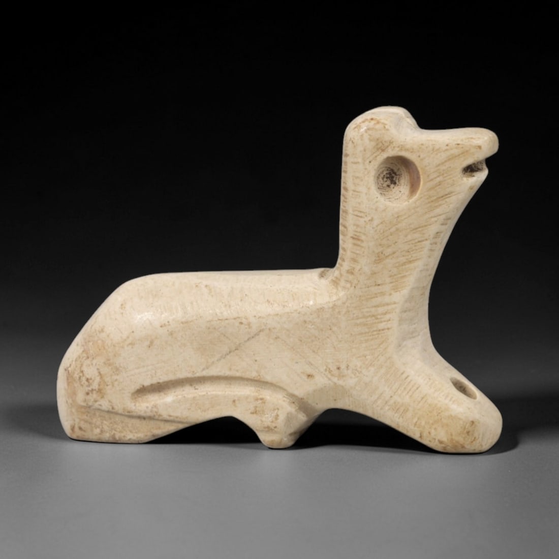Ancient Steatite Bovid Amulet - Near Eastern Animal Figurine, 59AR: This artifact is carved from a fine-grained, creamy-colored steatite, exhibiting a smooth, matte finish and subtle surface variations consistent with age. The form depicts a stylized bovid, likely an 