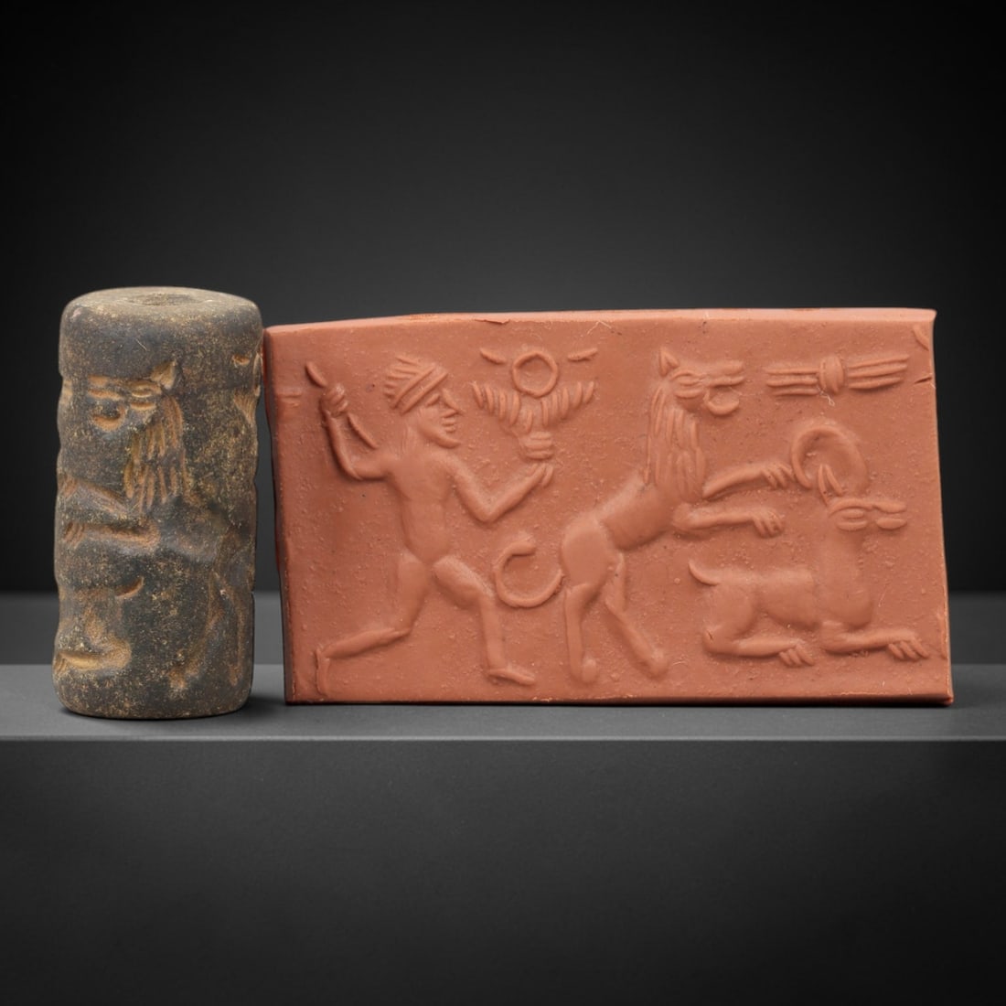 Ancient Steatite Cylinder Seal - Mesopotamian Mythological Combat Scene, 72AN: Carved from dense steatite, this ancient Mesopotamian cylinder seal features a dynamic linear relief composition of a human figure, lion, and caprine creature in a mythological combat scene, executed