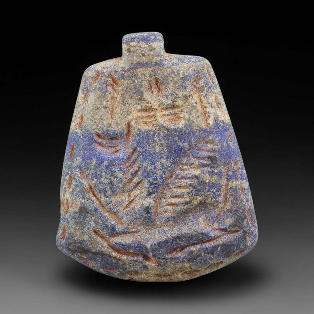 Ancient Lapis Lazuli Amulet - Near Eastern Carved Figurine, 44BA: Carved from lapis lazuli, the amulet takes a bell-shaped form with a suspension loop at the top, designed for wear as a protective talisman. The front face is incised with stylized linear and foliate 