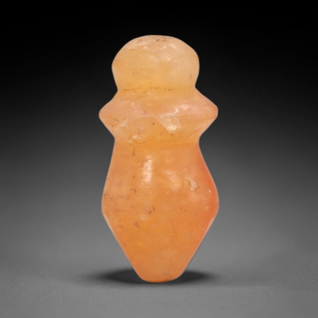 Ancient Carnelian Phallic - Egyptian Amulet Figurine, 73XS: Carved from warm, translucent carnelian with subtle surface inclusions and natural patination, this amulet takes the form of a stylized phallic amulet, featuring a rounded knobbed terminal, a distinct