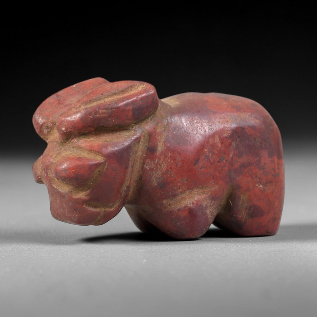 Ancient Red Stone Zoomorphic - Near Eastern Amulet Figurine, 24AS: This amulet is carved from dense red stone, exhibiting a rich, earthy patina indicative of long-term burial in ancient Near Eastern contexts. The form depicts a stylized zoomorphic creature, rendered 