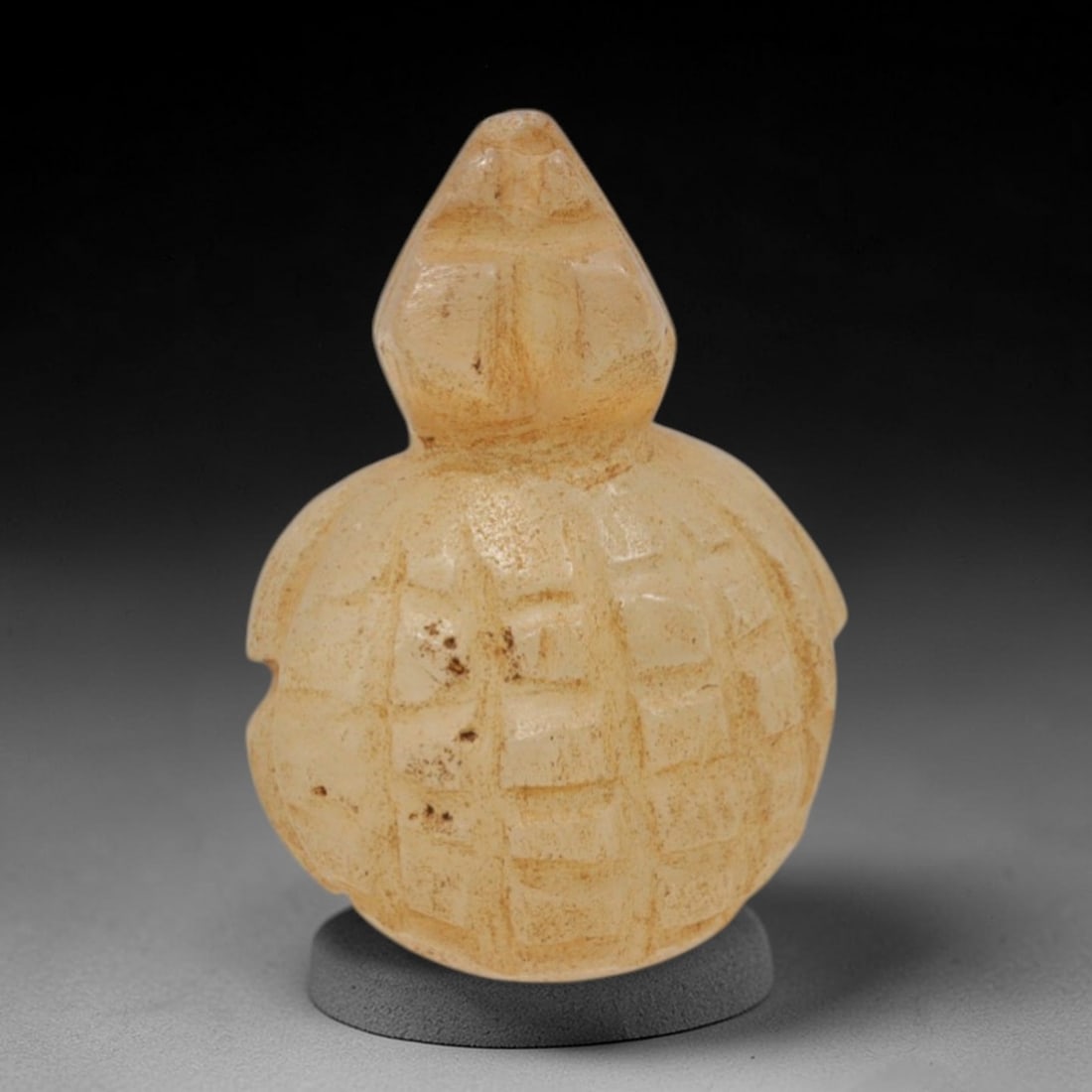 Ancient Chalcedony Tortoise Amulet - Near Eastern Figurine, 15XT: This amulet is carved from pale, translucent chalcedony with natural earthy inclusions and a warm, matte patina across its surface, executed in a stylized, compact form that emphasizes the tortoise's 