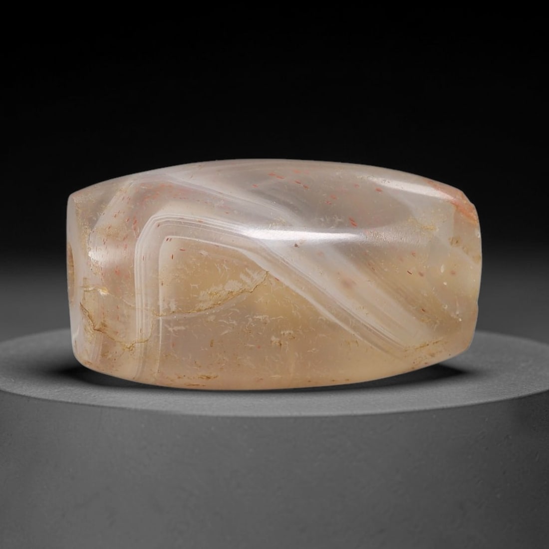 Ancient Agate Bead - Silk Road Cylinder Amulet, 71BC: Carved from banded agate, the bead features a smooth cylindrical barrel form with a polished surface that highlights the stone's natural diagonal concentric banding, ranging from creamy white to warm