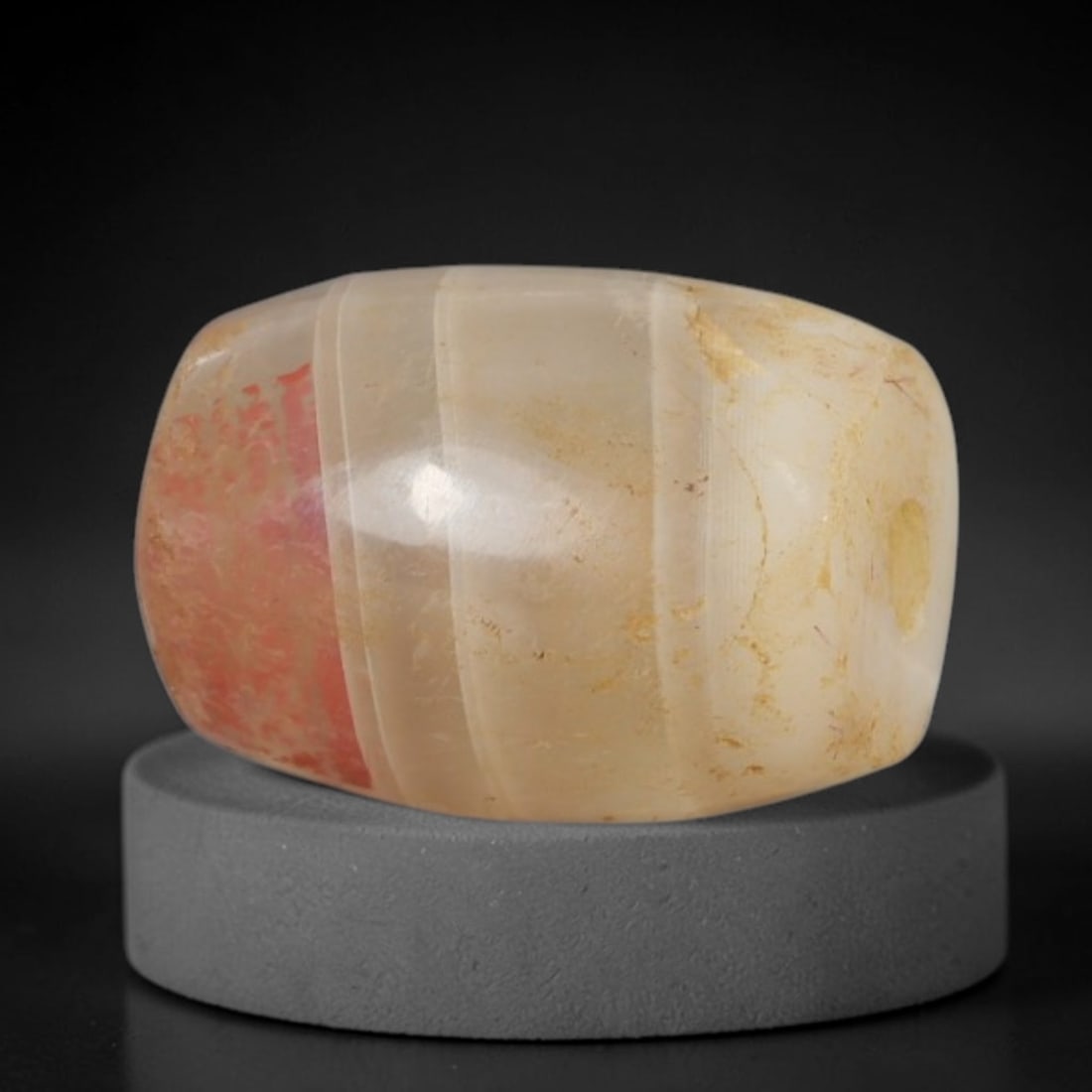 Ancient Agate Bead - Bactrian Silk Road, 94BA: Carved from banded agate, the bead is fashioned in a barrel form with a central perforation for suspension. The stone displays natural concentric banding in creamy beige and soft translucent tones, ac