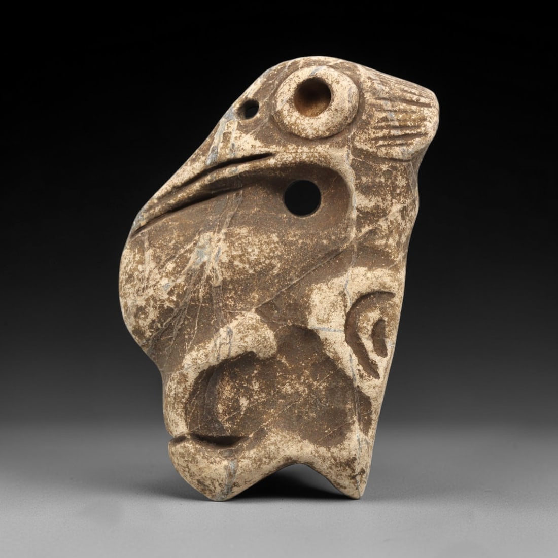 Ancient Stone Zoomorphic Amulet - Near Eastern Figurine, 83ZV: This artifact is a carved stone amulet of zoomorphic form, crafted from a coarse-grained, beige-hued stone characteristic of ancient Near Eastern lithic craftsmanship. The piece features a stylized an