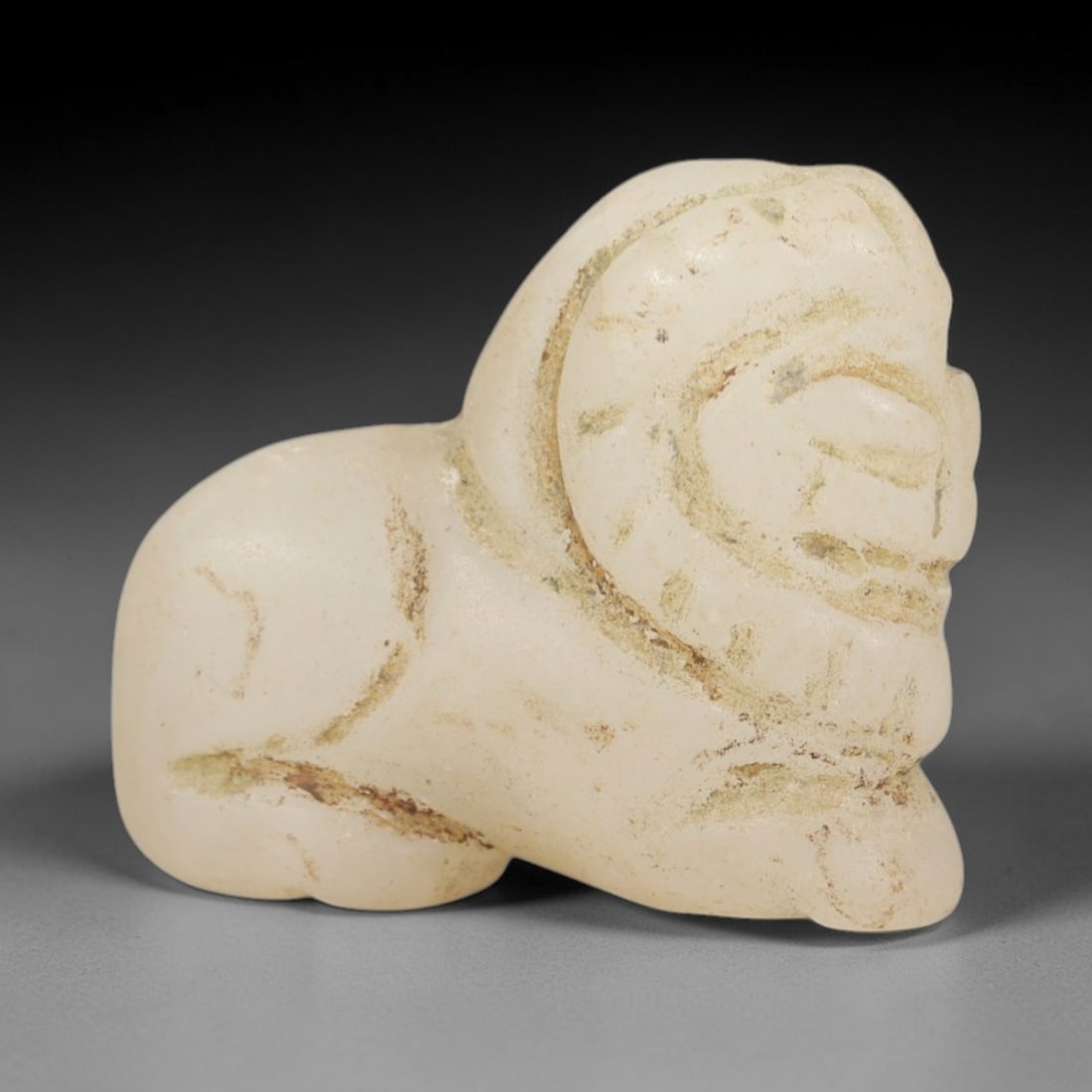 Ancient Chalcedony Lamassu Amulet - Near Eastern Figurine, 74AR: This artifact is carved from pale, milky-white chalcedony, exhibiting a smooth, matte finish with subtle natural inclusions and faint surface wear consistent with age. The form is a stylized lamassu, 