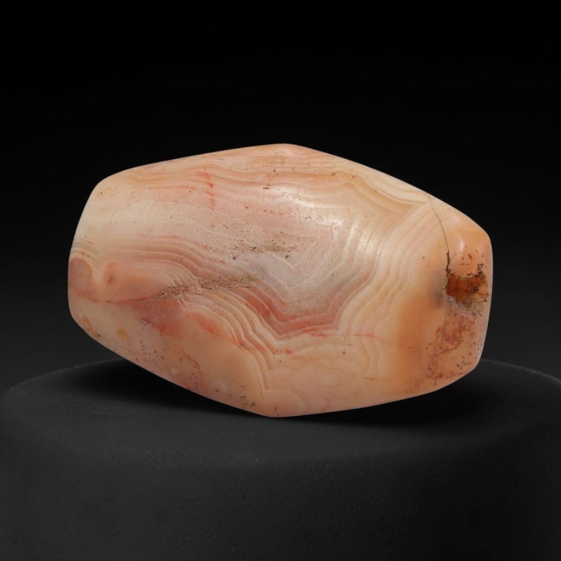 Ancient Agate Bead - Indus Valley Banded Bead, 11XW: This bead is carved from translucent peach-pink banded agate, shaped into a stout, faceted barrel form with a centrally drilled axial suspension hole, characteristic of Indus Valley (Harappan) lapidar