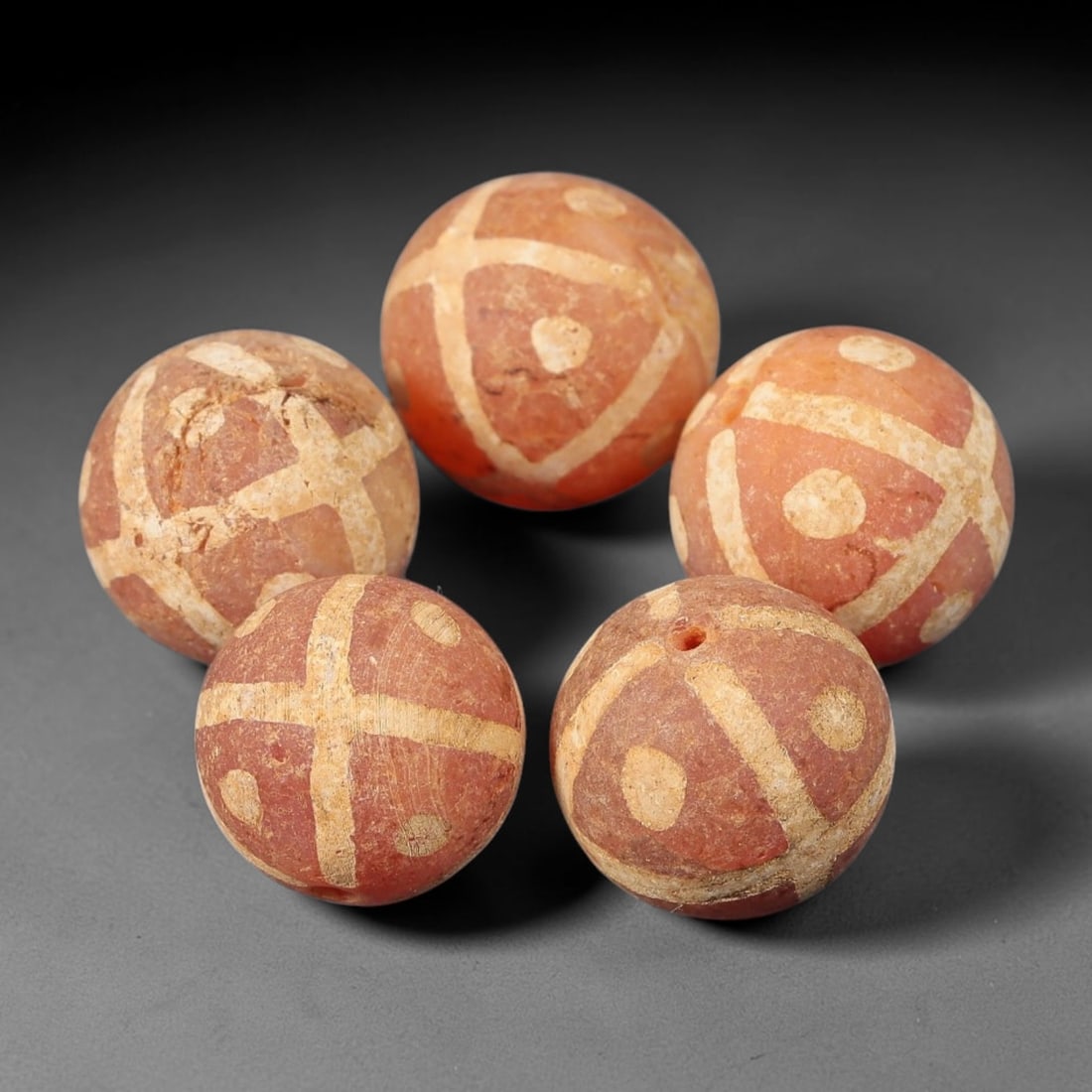 Ancient Gandhara Carnelian Etched Beads, Set of 5, 48BE: Carved from natural carnelian, this set of five spherical beads features intricate white etched geometric cross motifs and circular accent details across their surfaces. Each bead has a lateral drille