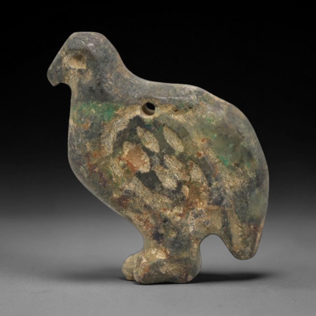 Ancient Turquoise Bird - Near Eastern Amulet Pendant, 3XV: This artifact is a carved turquoise bird amulet, featuring a stylized avian form with a distinct suspension hole for wearability. The surface displays incised linear detailing across the body, evoking