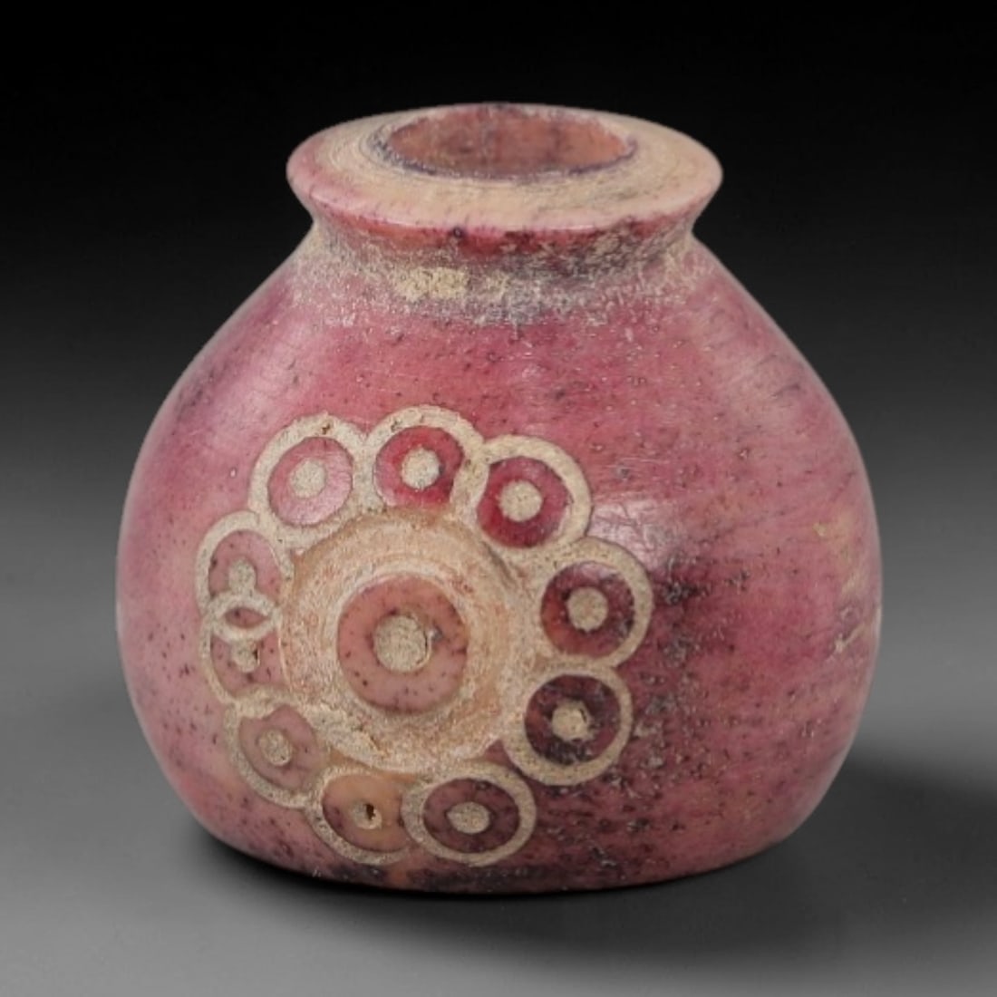 Ancient Bone Spindle Whorl - Near Eastern Dot-in-Circle Motif, 100AH: This ancient Near Eastern spindle whorl is crafted from bone, featuring a convex form with a central perforation. The surface is incised with a prominent dot-in-circle motif arranged in concentric ban