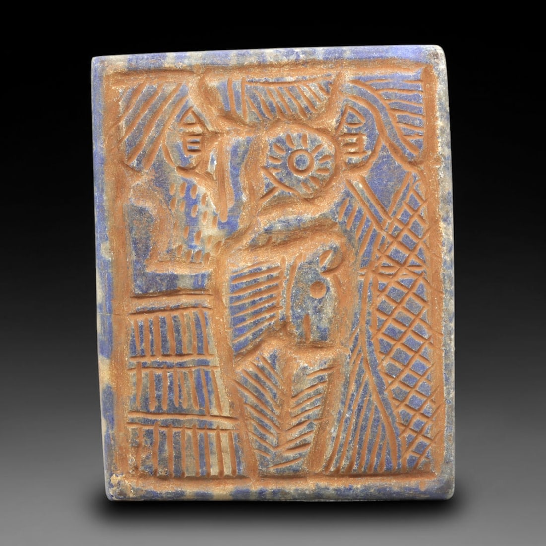 Near Eastern Lapis Lazuli Plaque - Tribal Art Two Figure Relief, 83ZY: Carved from lapis lazuli, this square plaque features a deeply incised relief composition depicting two facing anthropomorphic figures, rendered in a stylized Near Eastern tribal idiom. A central sun-