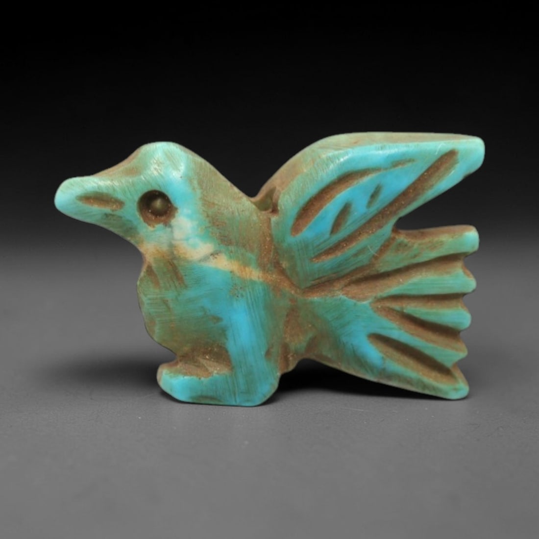 Ancient Turquoise Bird Amulet - Egyptian Animal Figurine, 21ZS: This artifact is a carved turquoise bird amulet, crafted in the stylized zoomorphic tradition of ancient Egypt. The amulet depicts a bird in flight with simplified yet distinct anatomical features, in