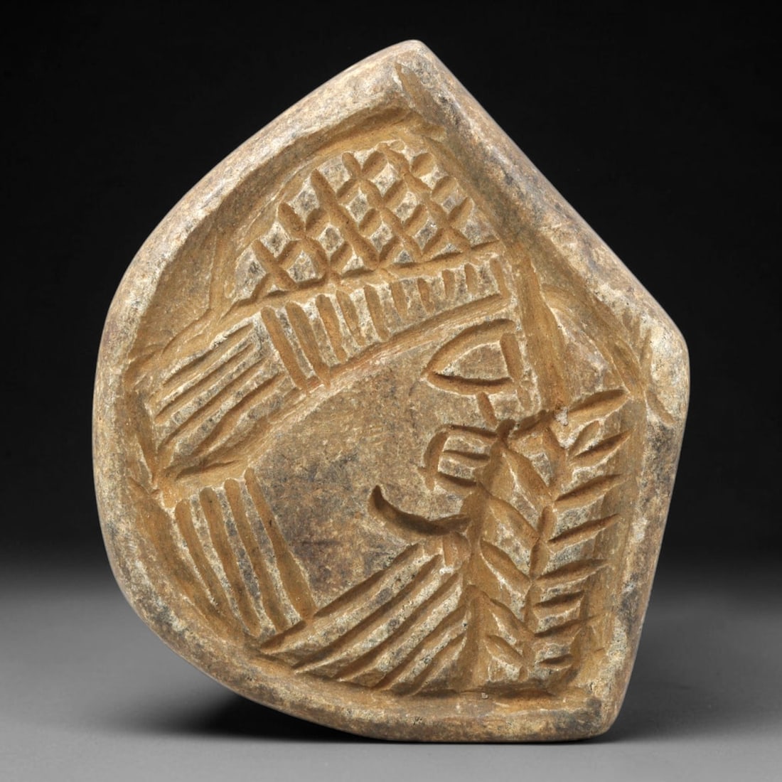 Ancient Stone Plaque Relief - Near Eastern Human Head Figurine, 15ZY: Carved from a single piece of stone, this irregularly shaped relief plaque depicts a stylized human head in profile, rendered in the linear, incised artistic tradition of the ancient Near East. The fi