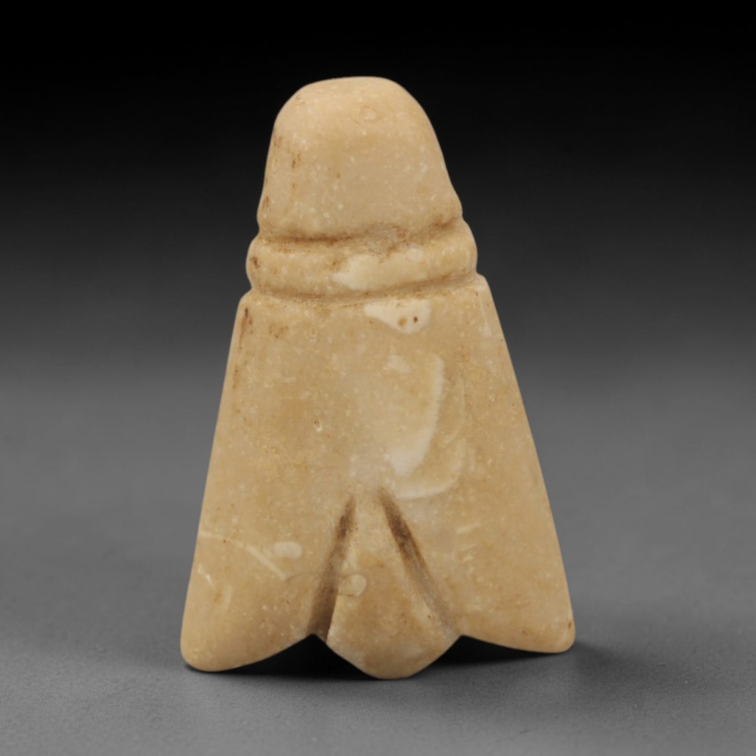 Ancient Stone Fly - Egyptian Amulet Pendant, 37XR: Carved from pale beige stone, this amulet depicts a stylized fly with a domed head, narrow neck, and broad, wing-like lower body terminating in a split tail. The form and iconography are characteristi