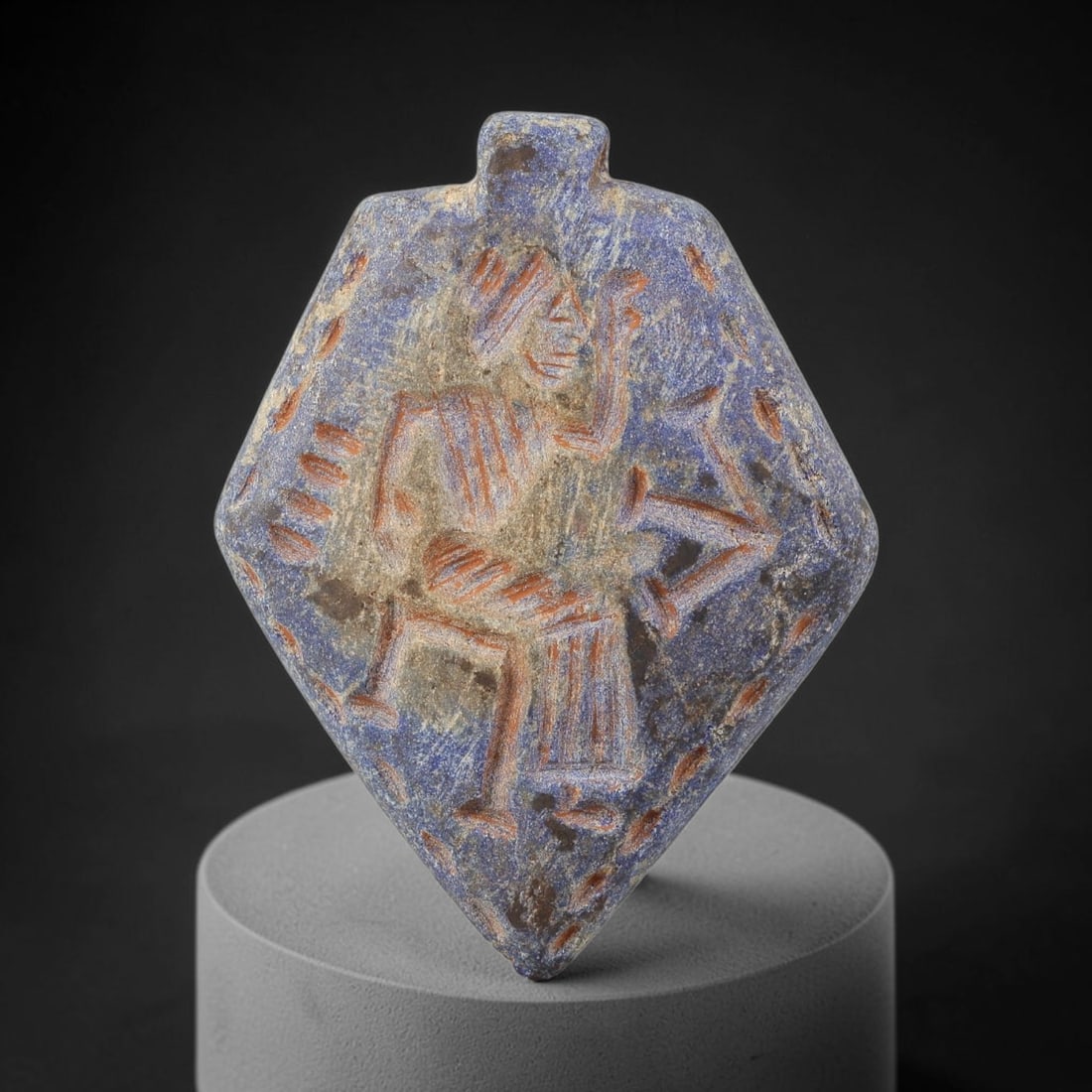 Ancient Lapis Lazuli Amulet - Near Eastern Dancing Figurine, 13BA: Carved from lapis lazuli, the amulet takes a diamond-shaped form with a suspension loop at the top, designed for wear as a protective talisman. The front face is incised with a stylized dancing anthro