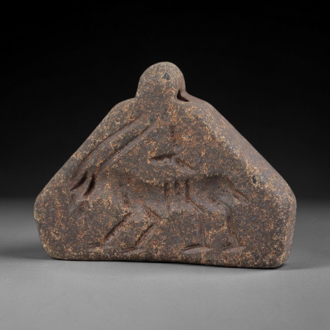 Ancient Steatite Amulet - Near Eastern Zoomorphic Pendant, 9FY: Carved from a mottled steatite (soapstone) plaque, this amulet takes the form of a stylized zoomorphic figure-likely a bird or feline-in profile, with incised linear details defining its limbs, body,