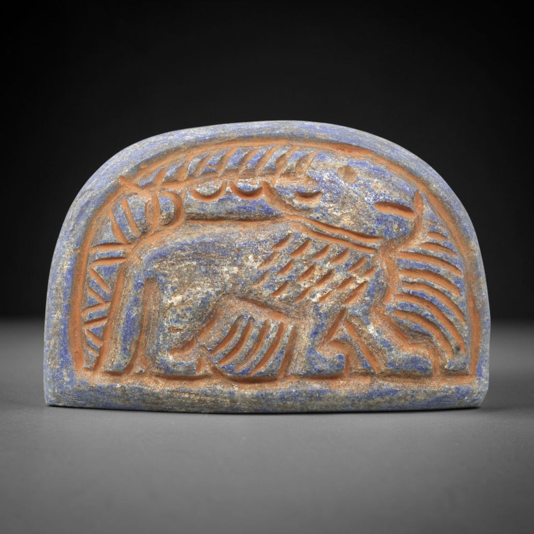 Near Eastern Lapis Lazuli Plaque - Tribal Art Feline Figure Relief, 94ZY: Carved from lapis lazuli, this arched plaque features a deeply incised relief depiction of a stylized feline figure, rendered in a geometric Near Eastern tribal idiom. The animal is defined by linear 