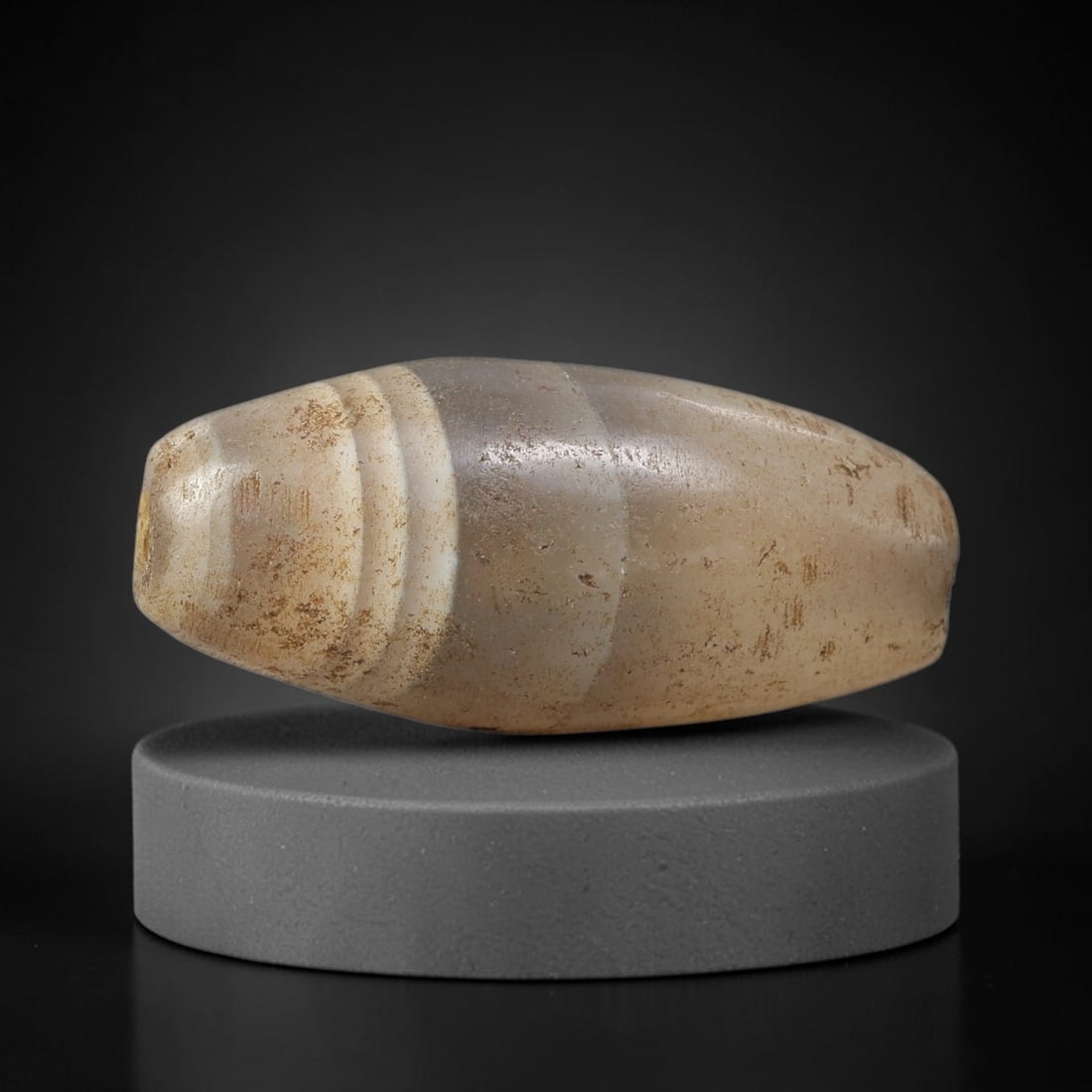 Ancient Banded Agate Bicone Bead - Near Eastern Artifact, 16BC: This artifact is crafted from natural banded agate, shaped into a large elongated bicone (tapered) form with a prominent central white band and three concentric white bands at one terminal. The bead f