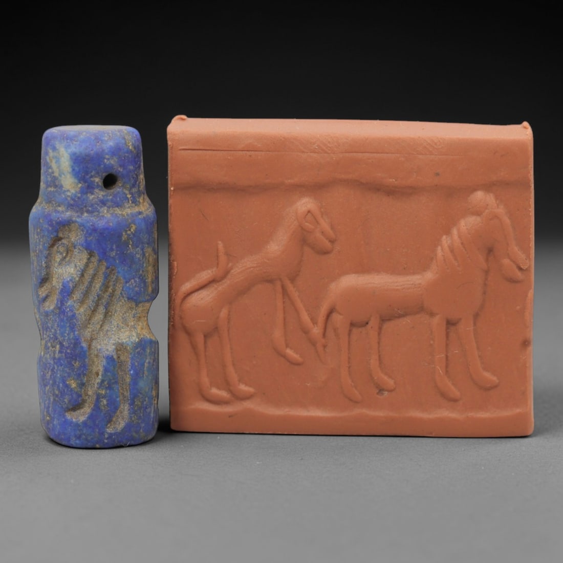 Ancient Lapis Lazuli Cylinder Seal - Near Eastern Glyptic Art, 44ZQ: Carved from lapis lazuli stone, this ancient Near Eastern cylinder seal features a cylindrical form with raised relief carvings depicting stylized equine figures with detailed linear patterns. The sea