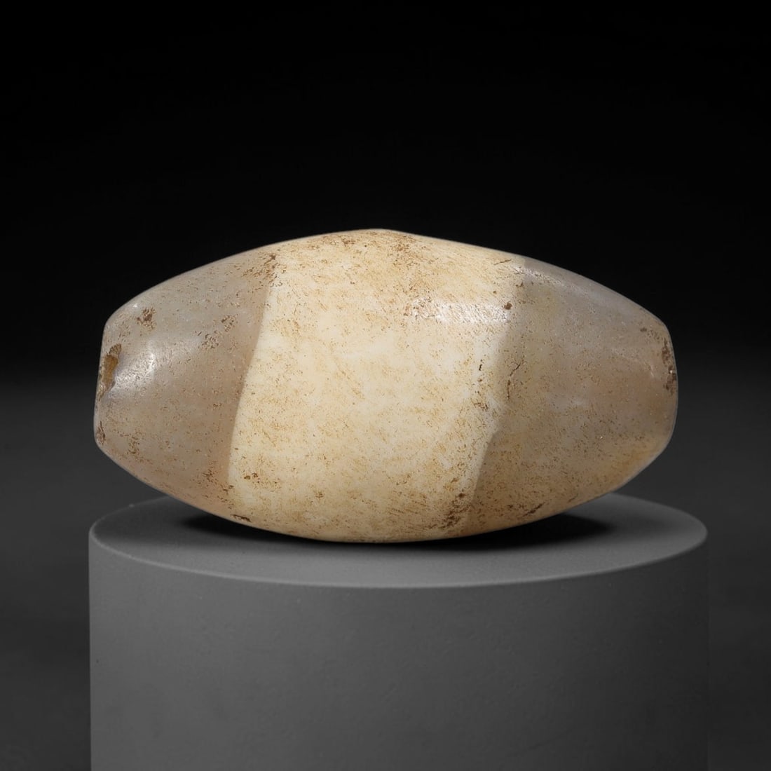 Ancient Agate Bead - Silk Road Bicone Amulet, 28BC: Carved from banded agate, the bead features a smooth symmetrical bicone (double-pointed) form with a polished surface that highlights the stone's pale milky base and subtle internal banding, heavily a
