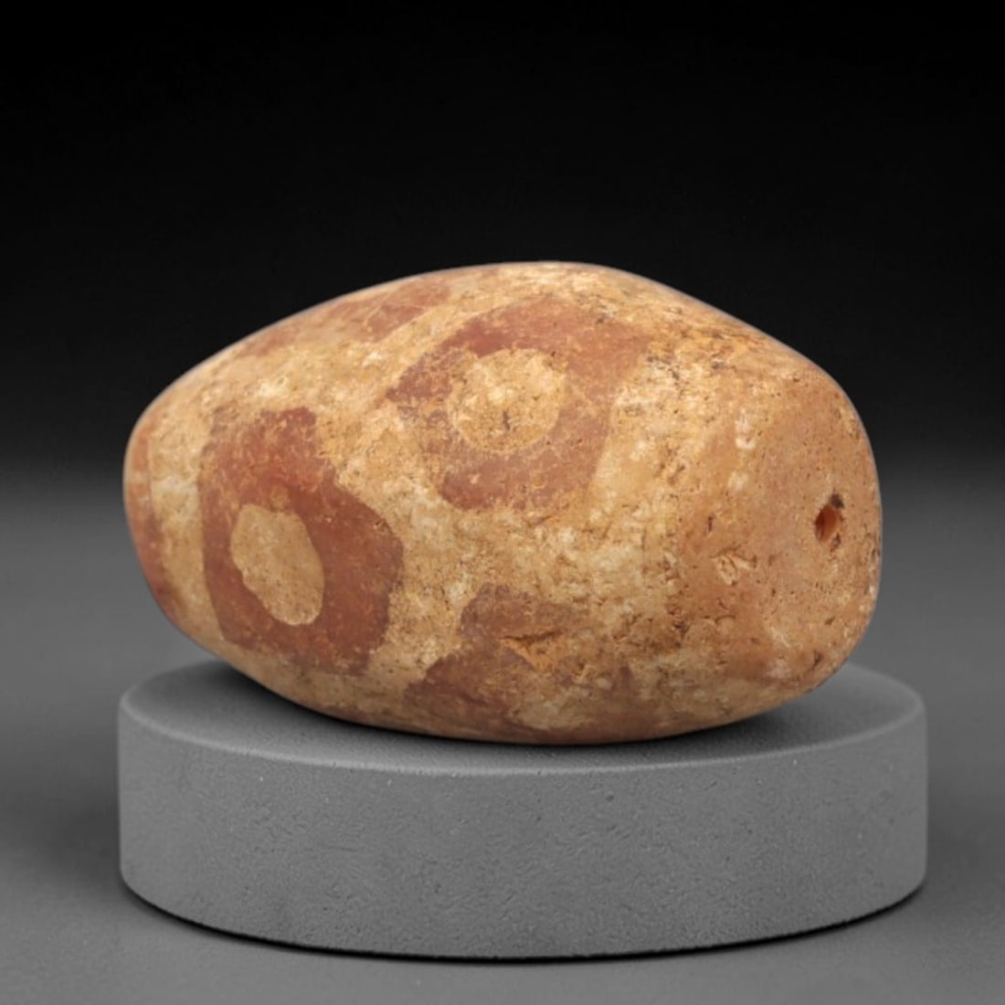 Ancient Carnelian Etched Bead - Gandhara Single Amulet, 30XY: A single large barrel-shaped bead crafted from carnelian, decorated with etched circular and geometric motifs in a pale white/cream pigment, characteristic of Gandharan decorative traditions. The bead
