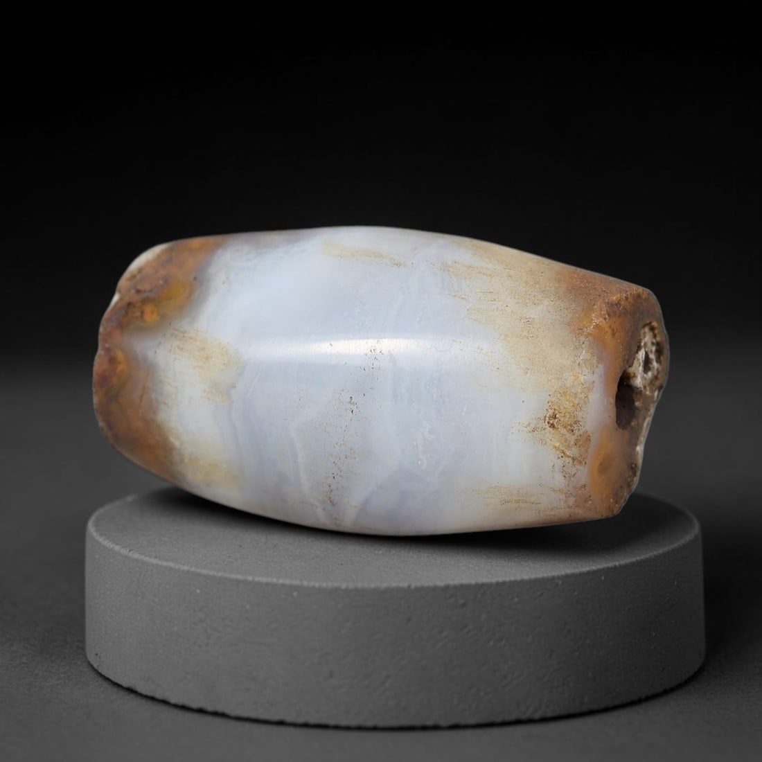 Ancient Banded Agate Bead - Indus Valley Artifact, 72BD: This artifact is crafted from natural banded agate, shaped into an elongated faceted barrel form with a soft milky-blue base and rich rust-brown terminal banding. The bead features a central perforati
