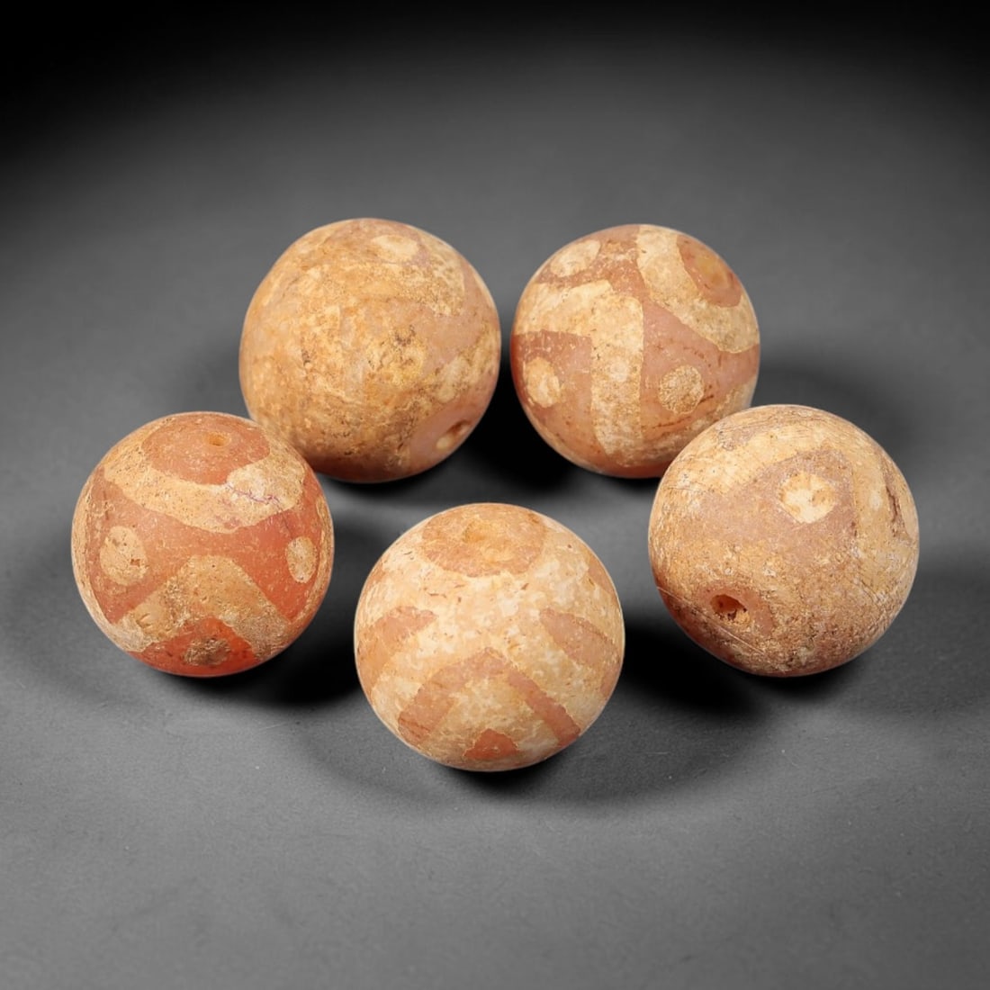 Ancient Gandhara Carnelian Etched Beads, Set of 5, 45BE: Carved from natural carnelian, this set of five spherical beads features a variety of white etched geometric motifs, including circular, cross, and abstract designs across their surfaces. Each bead ha