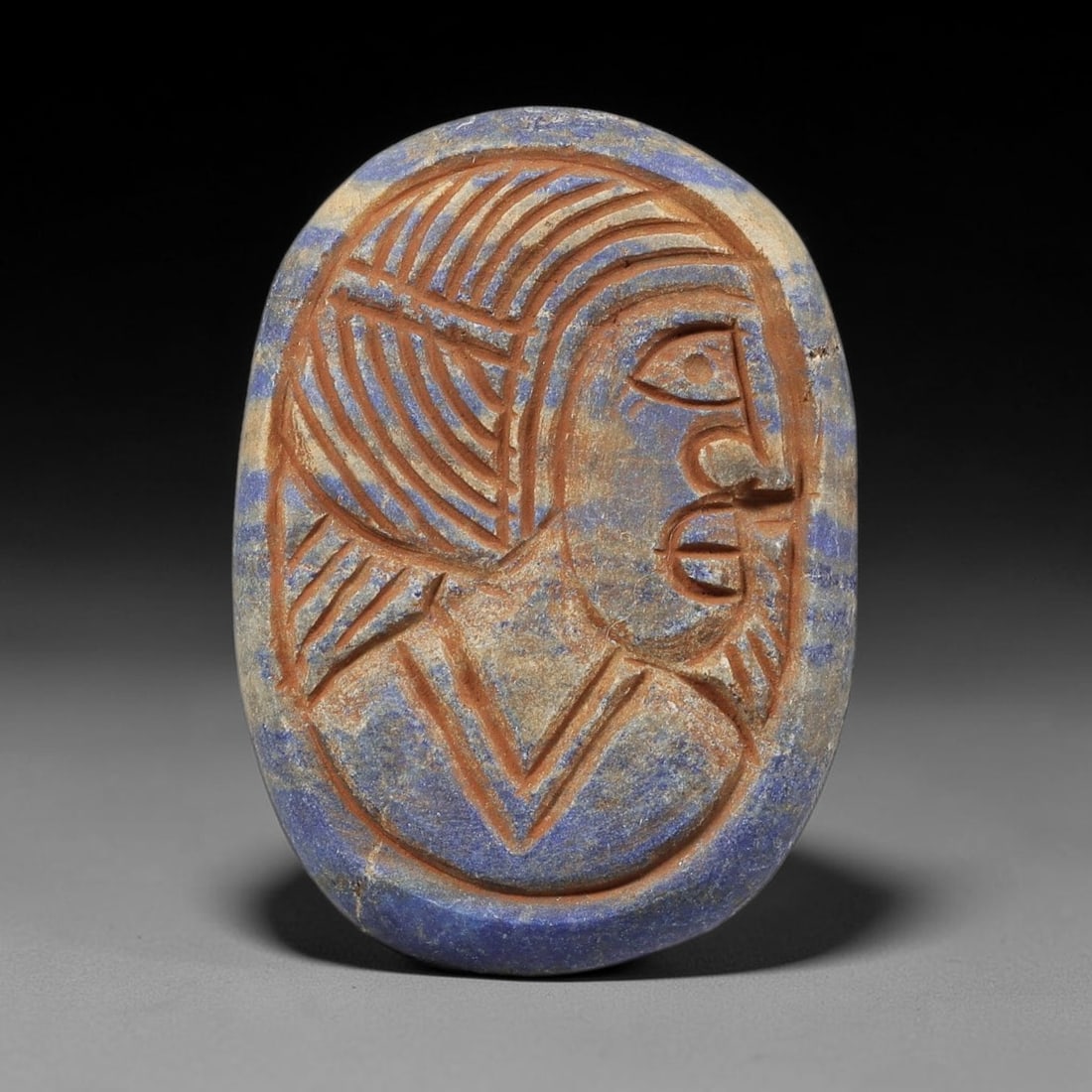 Near Eastern Lapis Lazuli Plaque - Tribal Art Figure Bust Relief, 92BF: Carved from lapis lazuli, this oval plaque features a relief depiction of a stylized human figure in profile, executed in the linear, expressive style characteristic of Near Eastern tribal art. The fi
