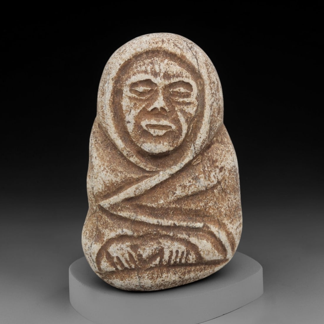 Ancient Stone Edo Monk - Japanese Buddhist Figurine, 24FX: Carved from a light-colored, granular stone with a weathered, earthy patina, this artifact depicts a seated Edo-period Buddhist monk, wrapped in a hooded robe with incised linear folds defining the dr