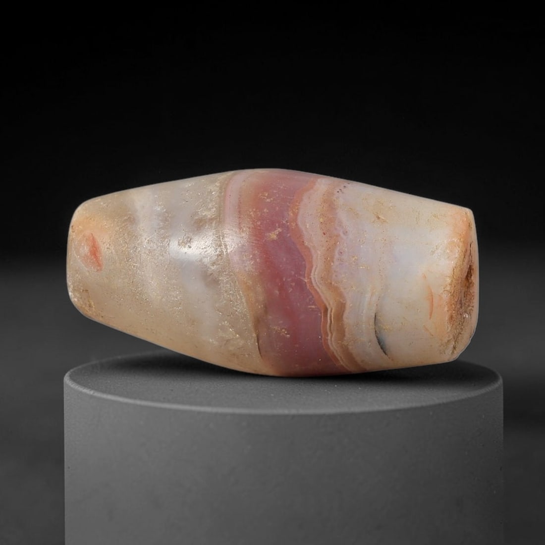 Ancient Agate Bead - Silk Road Bicone Amulet, 3BC: Carved from banded agate, the bead exhibits a symmetrical bicone form with a smooth, polished surface that highlights the stone's natural concentric banding, including a striking central band of warm