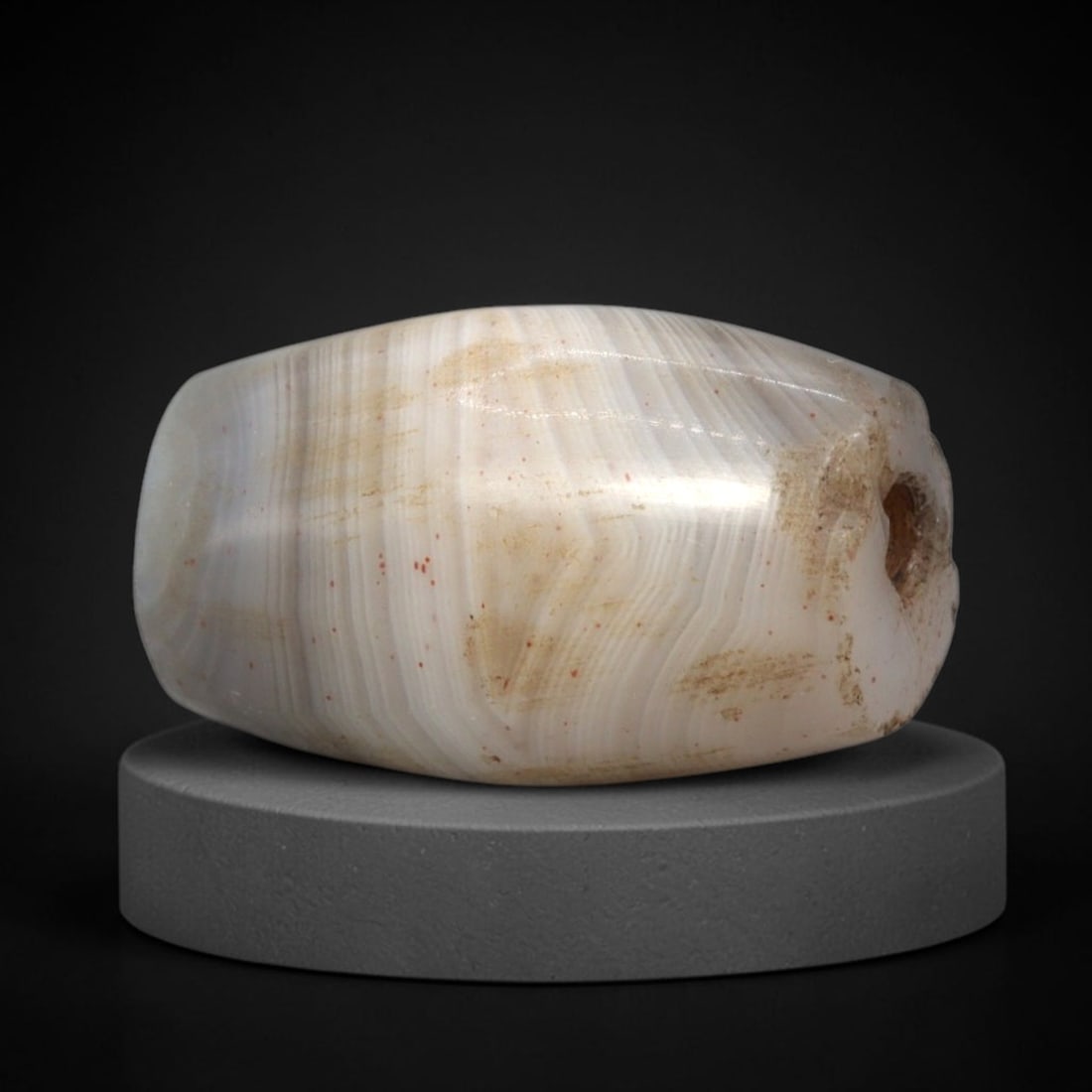 Ancient Banded Agate Bead - Western Asiatic Silk Road Amulet, 89XW: This bead is fashioned from banded agate with distinct concentric chevron-style stratification, a pale greyish base, and scattered red iron oxide inclusions, characteristic of ancient lapidary traditi