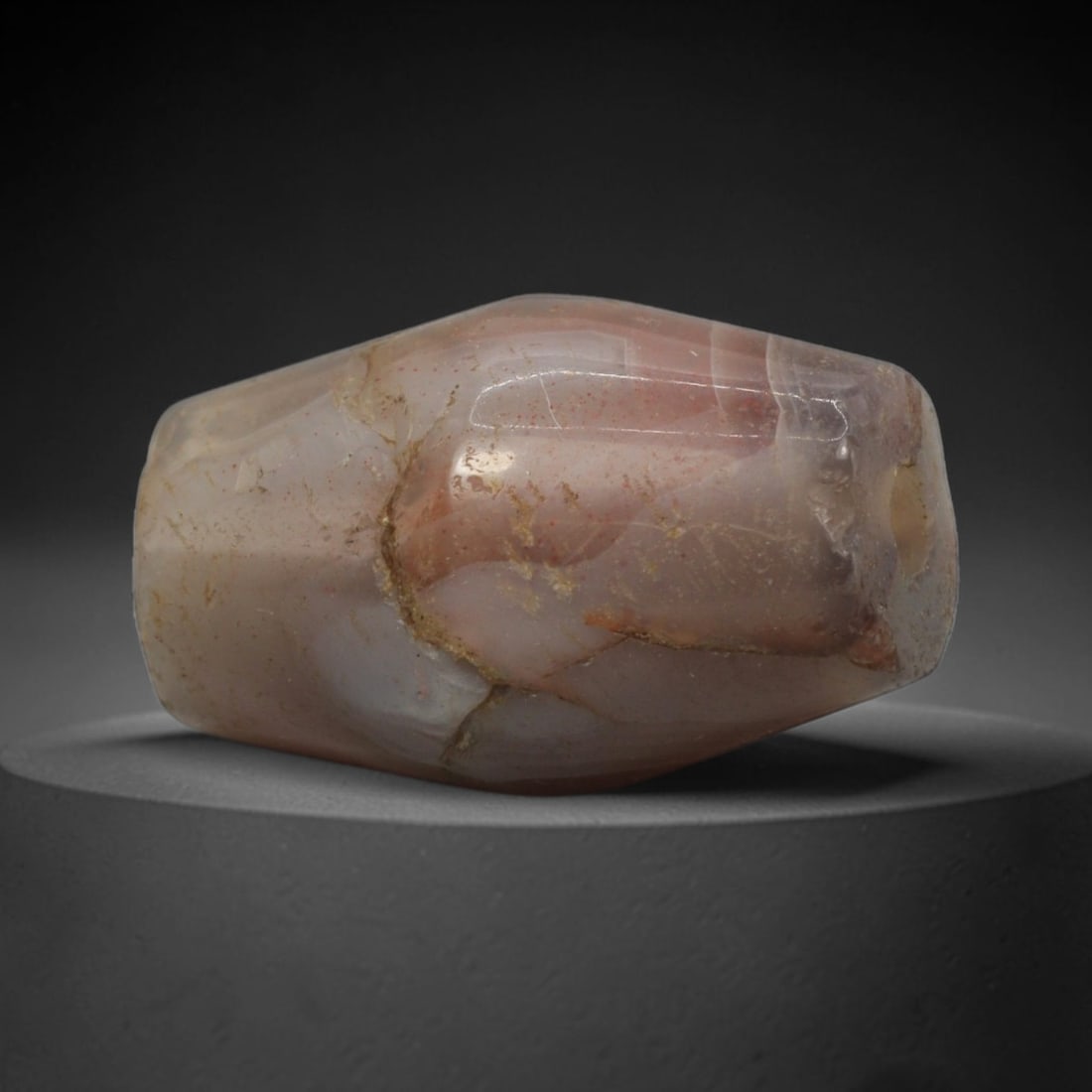 Ancient Agate Bead - Bactrian Faceted Banded Agate Bead with Red Inclusions, 64XW: This bead is carved from translucent smoky-grey and creamy-white banded agate, shaped into a robust, faceted barrel form with a precisely centered axial drill hole, characteristic of ancient Bactrian