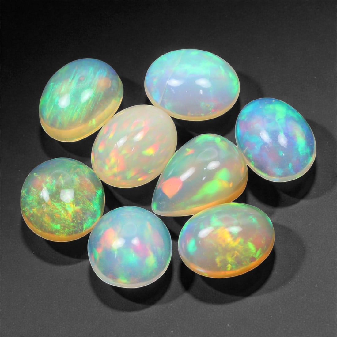 10.40 Carats Multicolor Welo Opal Selection - Natural Ethiopian Stones, 7-9mm, 16XK: A kaleidoscope of shifting fire dances across this glowing selection of Welo opals, offering flashes of electric green, neon pink, oceanic blue, and sunlit orange. The stones exhibit that signature et