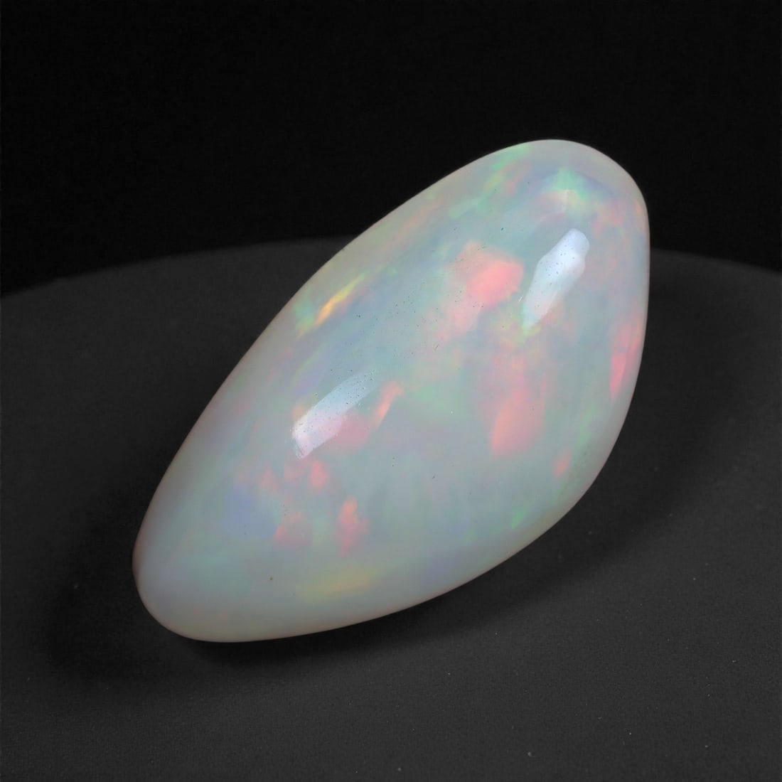 4.77 Carats Play-of-Color Welo Opal - Natural Ethiopian Gem 17x9mm, 43XA: This captivating Welo opal gleams with a luminous cascade of multi neon color that ripple across the stone's surface with every movement. The play-of-color is vivid and well-distributed, presenting a