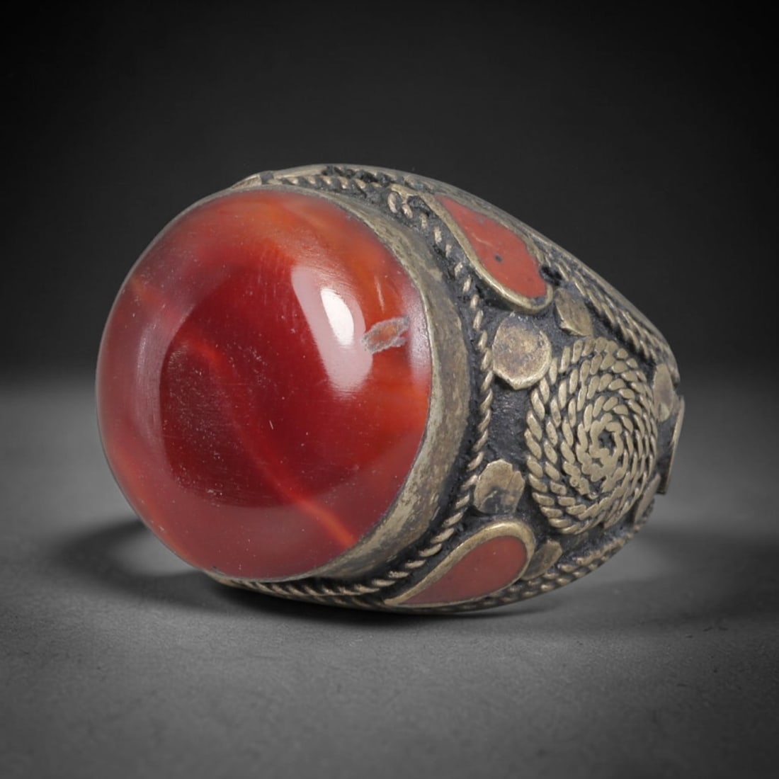Antique Silvered Ring - Eurasian Steppe Carnelian Cabochon, 23BK: This antique Eurasian Steppe ring is crafted from silvered metal with untested silver purity. The domed face features a large, vividly red carnelian cabochon with subtle natural banding and fine surfa