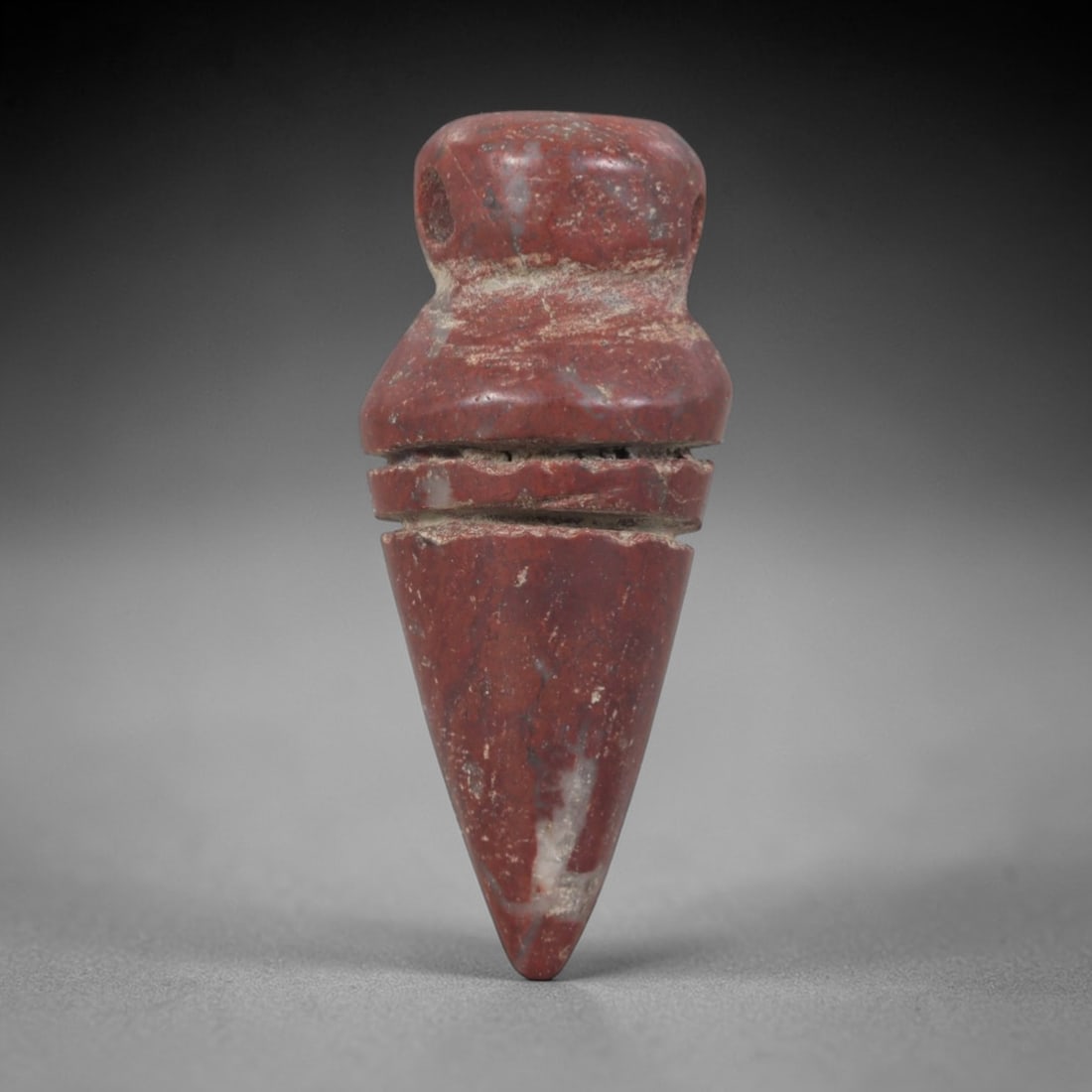 Ancient Stone Amulet - Egyptian Ritual Pendant, 48AP: This artifact is carved from variegated red stone with a weathered, earthy patina and subtle mineral veining, exhibiting precise incised linear detailing consistent with ancient Egyptian stoneworking