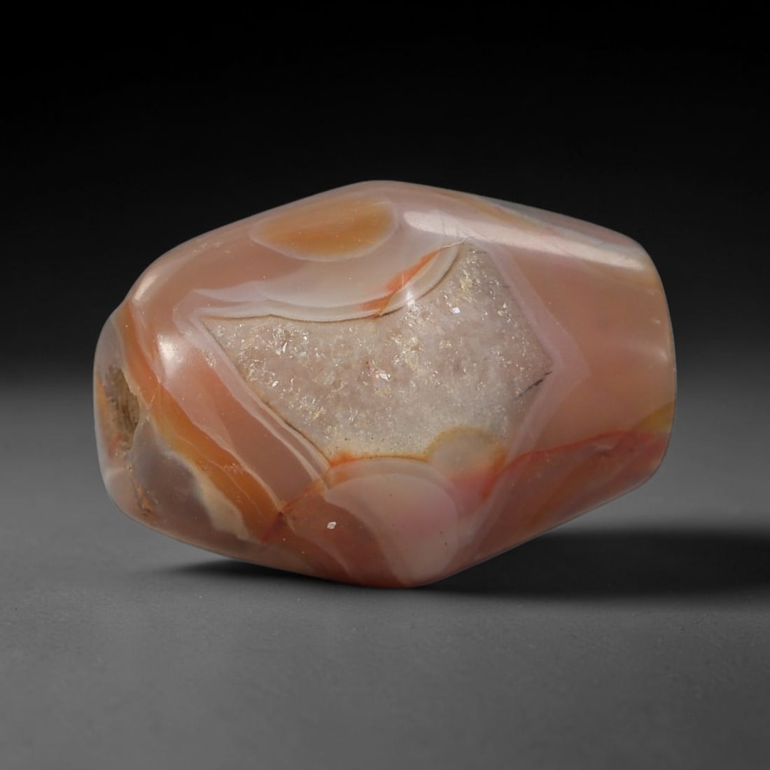 Ancient Agate Bead - Silk Road Amulet, 20BD: This artifact is crafted from variegated agate, showcasing soft bands of warm peach, creamy white, and translucent grey with a central druzy quartz inclusion, shaped into a smooth faceted barrel form 