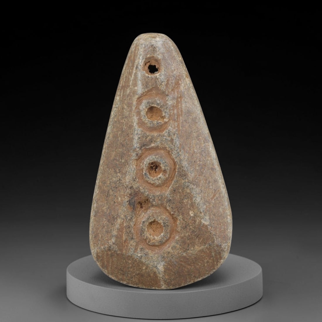Ancient Schist Geometric Amulet - Near Eastern Carved Pendant, 62FY: Carved from schist, this amulet takes the form of a stylized teardrop or triangular pendant, rendered in relief with bold, simplified carving. A drilled suspension hole at the top allows for wear, and