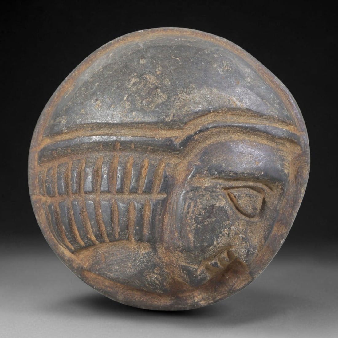 Ancient Stone Amulet - Near Eastern Bust Plaque Pendant, 43FY: Carved from dark stone, the amulet is a circular plaque crafted in the ancient Near Eastern style, featuring a raised relief portrait of a human bust in profile. The surface bears incised details rend