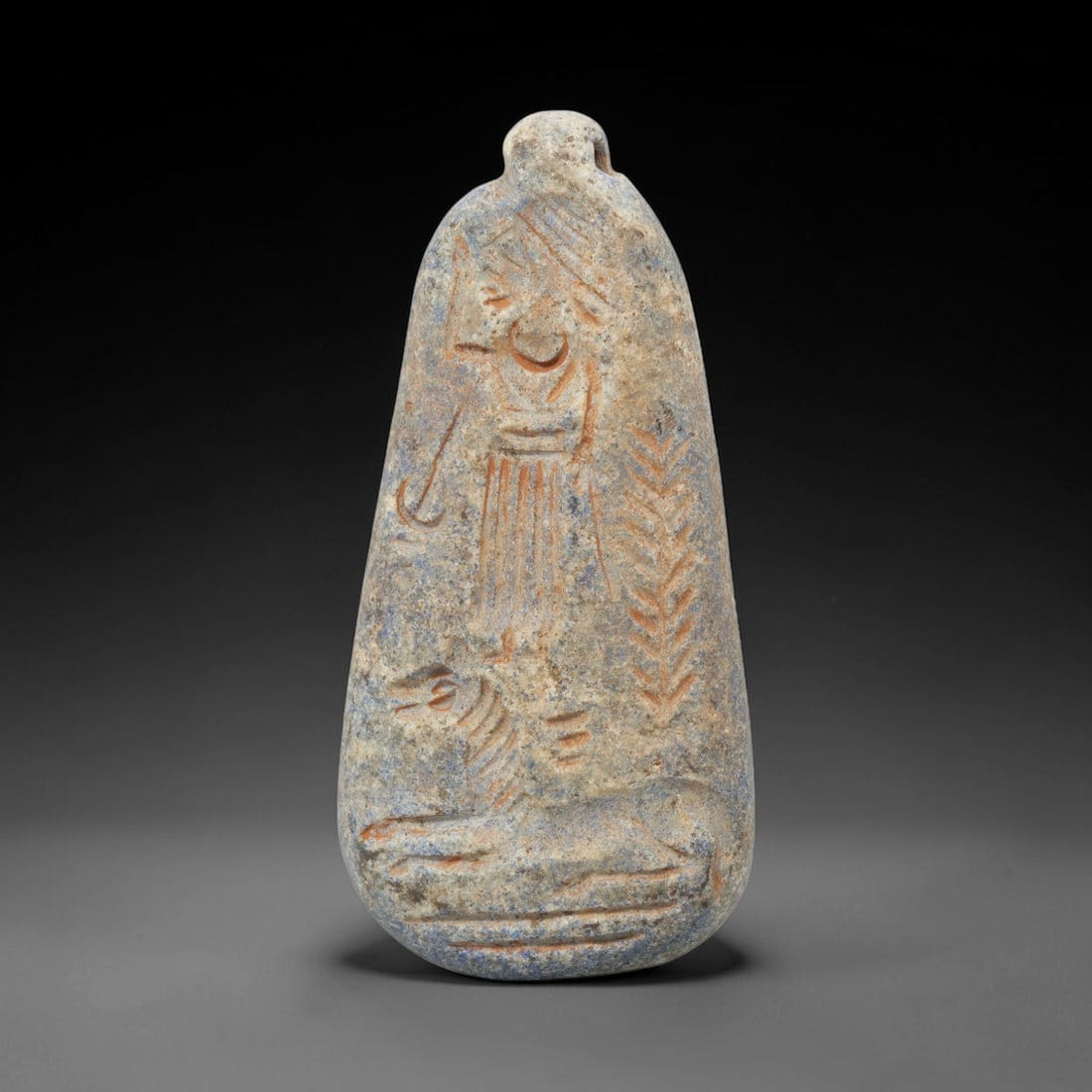 Ancient Lapis Lazuli Amulet - Near Eastern Human & Lion Figure, 35ZX: Carved from lapis lazuli, this amulet features a relief scene depicting a standing human figure positioned above a recumbent lion, rendered in the stylized glyptic tradition of the ancient Near East. 